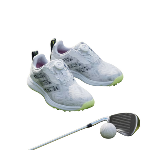 The Adidas 2025 Codechaos BOA Junior Golf Shoes, featuring green soles and the BOA Fit System, are shown with a golf club and ball on a plain white background.