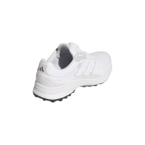 The Adidas 2025 Zoysia Boa Spikeless Women’s Golf Shoes in Cloud White feature subtle gray accents and a textured black sole, shown from the side and rear for women’s golf enthusiasts seeking style and comfort.