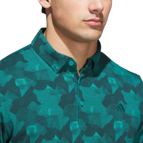 A man wears the Adidas Mens Go-To Printed Polo Shirt in Pure Teal/Ivy, made from lightweight performance fabric. The cropped image highlights the small Adidas logo on his chest, showing only his lower face and upper torso.