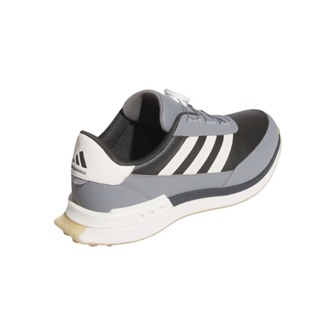 The Adidas S2G 24 BOA Men’s Golf Shoe in Carbon, Chalk White, and Grey Three has three white side stripes, a white heel, a light sole, and features the BOA Fit System. The spikeless shoe is shown from the back left angle.