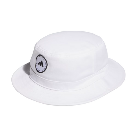 The Adidas Solid Bucket Hat in Collegiate Navy features a black and white circular logo patch with the Adidas symbol and text on the front. Designed for sun protection, its perfect for outdoor activities.