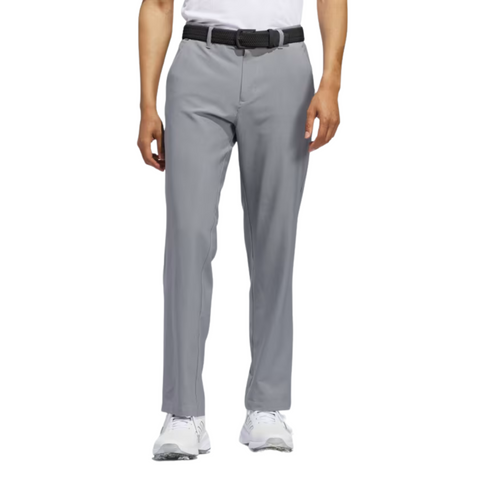 A person wearing Adidas Ultimate365 Mens Golf Pants in light gray, paired with a black belt, white shirt, and sneakers stands against a white background. The cropped image highlights these stylish Adidas pants designed for comfort and performance.
