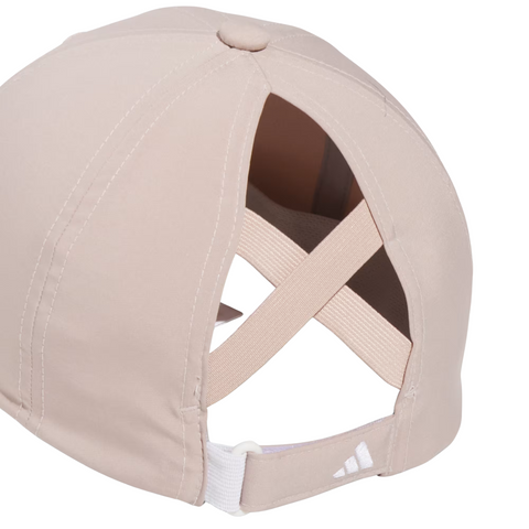 The Adidas Womens Crisscross Hat in Wonder Taupe features crisscross elastic bands, an adjustable white strap with a small Adidas logo, and is perfect for golf with its comfortable sun protection.