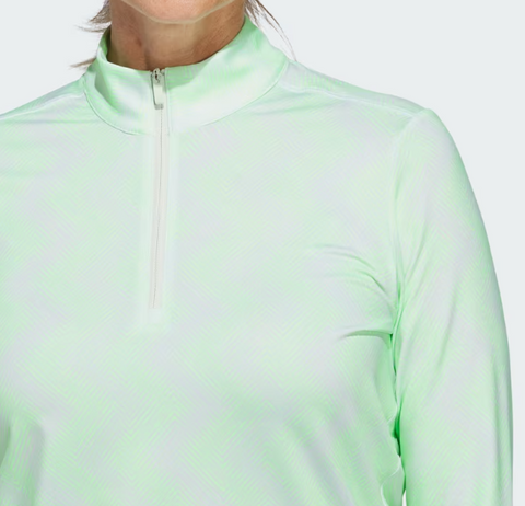 A woman wears the Adidas Womens Ultimate365 Printed Quarter-Zip Pullover in light green, a long-sleeve golf top made with recycled materials and featuring a subtle pattern. Only her lower face, neck, and upper body are visible.