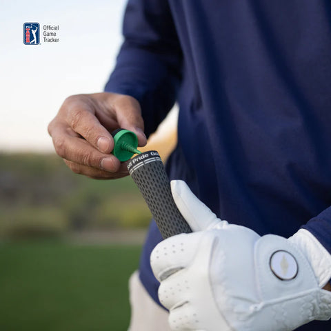 A golfer in a white glove attaches an Arccos Smart Sensors Gen 4 Green by Arccos to a golf club grip, with the PGA Tour Official Game Tracker logo visible in the corner.