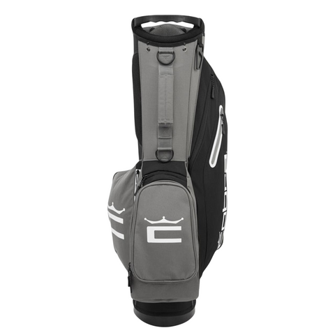 The Cobra 2025 Signature Stand Bag | Black/Grey from golf360nz stands upright, features white logos, multiple zippered compartments, and offers a lightweight design—ideal for carrying all your golf essentials.