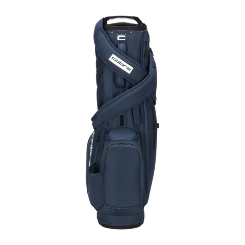 The Cobra Ultralite Pro Stand Bag 2025 by Cobra, in navy blue, features multiple zippered pockets, a top handle, and a shoulder strap. Lightweight and upright against a white background, it displays its modern golf bag design.