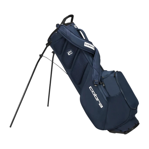 The Cobra Ultralite Pro Stand Bag 2025 by Cobra is shown in navy blue with dual shoulder straps, side pockets, and two extended legs for support. This lightweight golf bag combines style and convenience, displayed at an angle on a white background.