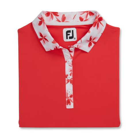 A folded FootJoy Floral Trim Short Sleeve Womens Polo in red features a white collar, placket with red floral pattern, white buttons, open collar design, and the FJ logo on the inside label.