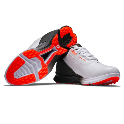 A pair of modern white FootJoy Fuel 25 Men’s Golf Shoes by FootJoy, featuring black heels and bright orange-red spikeless soles—one shoe stands upright, while the other is tilted to showcase the sole design.