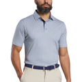 A man stands with arms relaxed at his sides, wearing a FootJoy Men’s Citrus Print Lisle Polo in white/navy, beige pants, and a navy belt. The golf shirt features ProDry performance fabric for comfort.