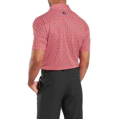 A man wearing the FootJoy Men's Floral Sketch Print Lisle Polo in Hibiscus/White, shown from the back with one hand in his pocket, paired with black trousers.