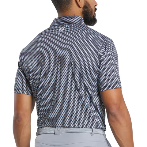 A man, seen from the back in light pants, turns his head to display the FootJoy Mens Lisle Houndstooth Geo Print Polo in black—a stylish performance golf shirt by FootJoy.