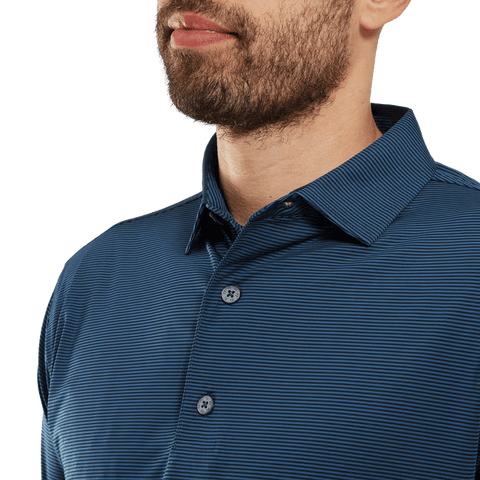 A close-up shows a man in the FootJoy Mens Micro Feeder Stripe Lisle Polo - Navy/Tonal, featuring its subtle stripes and collar with his lower face, neck, and upper torso visible.