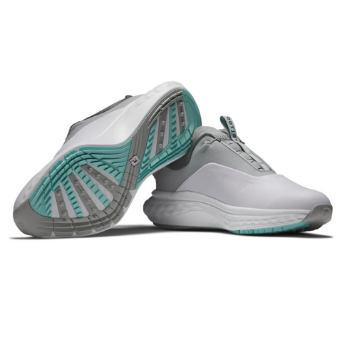 The FootJoy Quantum Mens Boa Golf Shoes by FootJoy feature modern spikeless design, white uppers with gray accents, and teal-turquoise outsoles showing a textured tread—perfect for style and performance on the course.