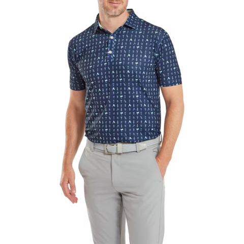 Front view of the FootJoy 19th Hole Polo worn by a model. The navy blue shirt features a fun, golf-themed print with icons. Paired with light grey trousers, the polo showcases its comfortable fit and modern design.