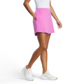 A person, visible from the waist down, wears a white sleeveless top, a FootJoy Women's Aerial Performance Knit Skort in Berry, and white sneakers against a white background.
