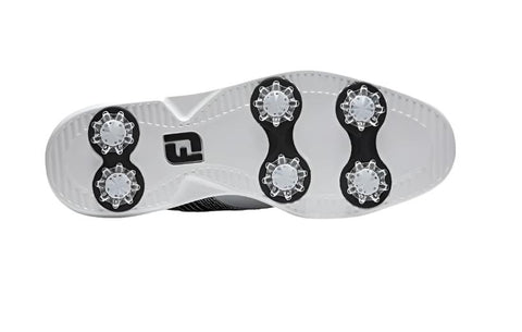 The image displays the underside of the FootJoy Women's Traditions Golf Shoes in White/Dark Multi Print (US 7), featuring six removable cleats for traction and a central FJ logo, showing these lightweight shoes’ stable golf course design.