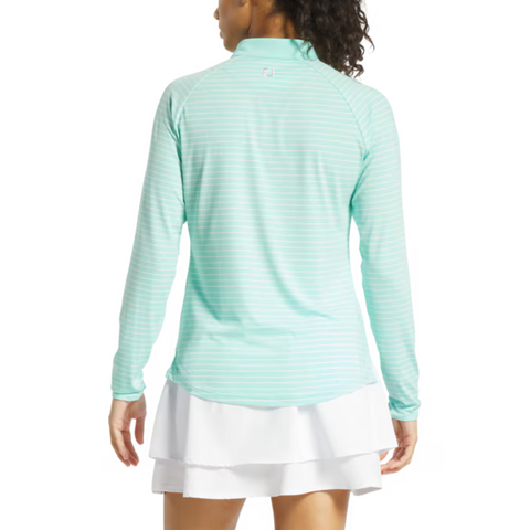 A woman with her back to the camera wears a FootJoy Womens 1/4 Zip Long Sleeve Sun Protection Shirt in light blue and white stripes, paired with a white skirt—ideal for comfortable, stylish days on the golf course.