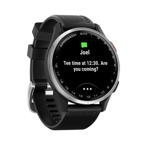 A black Garmin Approach S44 GPS Watch from Garmin shows a text from Joel: Tee time at 12:30. Coming? With a round face and textured silicone strap, its ideal for golf tech fans.