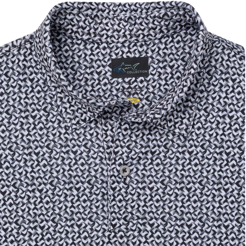Close-up of the Greg Norman Men’s Great White Mosaic Ultra Stretch Polo in black and white with a geometric pattern, two buttons, and a ‘Collection’ brand tag inside the collar.