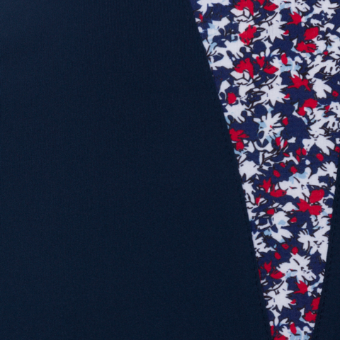 A close-up of the Greg Norman Women’s ML75 Liberty Sculpted Collar Polo in navy reveals a solid section beside a red, white, and blue floral pattern, showcasing this Greg Norman polo's stylish performance design.