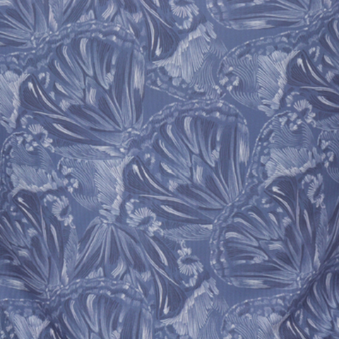 A close-up of the Greg Norman Women’s Play Dry Butterfly Polo in Vintage Indigo, featuring overlapping butterfly wing designs with intricate lines and blue shades for a detailed, textured look.