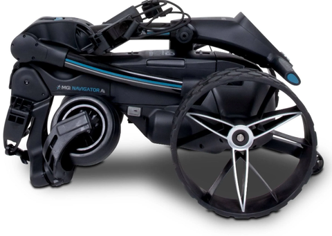 The MGI Ai Navigator GPS+ Electric Golf Trundler (with free accessory pack) features a black, compact, foldable design with two large wheels, shown folded for easy transport or storage.