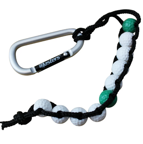 The Masters Golf Bead Stroke Counter by Masters features a silver carabiner and a black cord strung with mostly white and two green golf ball-style beads—an easy tool for keeping your golf score.