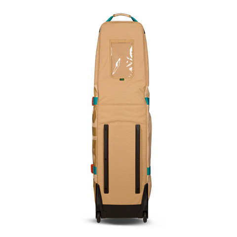 The Ogio Alpha Mid Travel Cover by Ogio is tan with teal and red accents, stands upright on two wheels, features a clear plastic window near the top, and has two black vertical bars at the bottom for club protection.