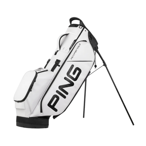 The Ping Hoofer Tour Stand Bag is a white golf bag with black accents, bold PING branding on the side, multiple zippered pockets for tour-level storage, and sturdy black stand legs to keep it upright.