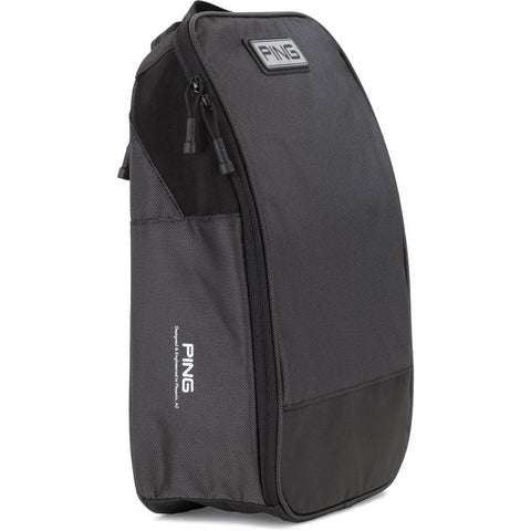 The Ecco Ping Shoe Bag is black with a zippered main compartment, side mesh pocket for ventilation, top handle, and features the Ping logo on a patch near the top and vertically printed near the bottom side.
