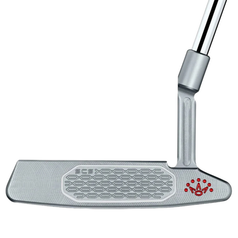 A close-up of the Scotty Cameron 2025 Studio Style Newport 2 Putter highlights its precision-milled face with a hexagonal pattern and small red crown logo near the heel. Part of the chrome shaft appears at the top right.