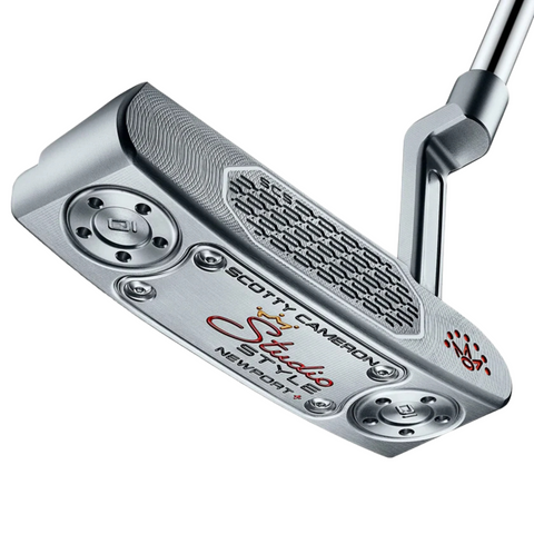 A close-up of the Scotty Cameron 2025 Studio Style Newport Plus Putter shows engraved branding, a precision milled silver head, a textured face insert, and red, black, and gold accents.