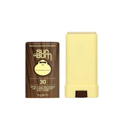 The Sun Bum SPF 30 Face Stick | 13g is displayed with its brown cap off beside the yellow stick, showing a cartoon monkey logo and white text on the packaging—ideal for mess-free sun protection while golfing.