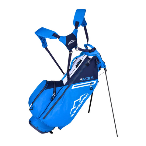 A Sun Mountain 2025 E-Lite Carry Bag in navy, blue, and white features dual shoulder straps, multiple zippered pockets, extended stand legs, and displays "E-LITE" on the side for easy identification.