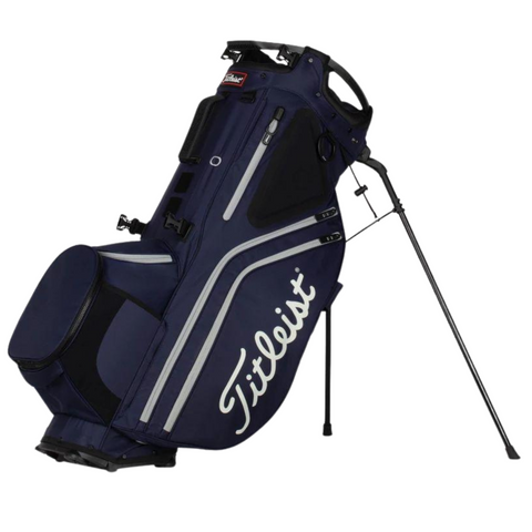 The Titleist Hybrid 14 Golf Bag by Titleist features a navy blue design with white accents, a retractable stand, the Titleist logo, and a 14-way top divider for organized club storage.