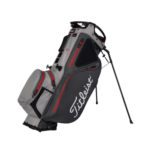 The Titleist Hybrid 14 Stadry Golf Stand Bag is a gray and black waterproof stand bag with red accents, white Titleist logo, extended legs, 14-way dividers, and multiple zippered pockets to keep your gear organized and protected.