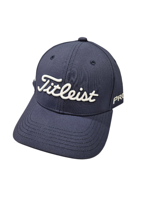 The Titleist Junior Tour Performance Cap is a navy blue kids’ golf cap with white “Titleist” embroidery on the front and “PRO” at the brim. It features visible stitching and a curved bill for classic style.