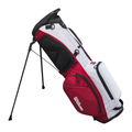 The Wilson Exo Lite Stand Bag in Black/Red/White features a stand, multiple zippered pockets, and a shoulder strap. This lightweight Wilson bag stays upright on its extended legs.