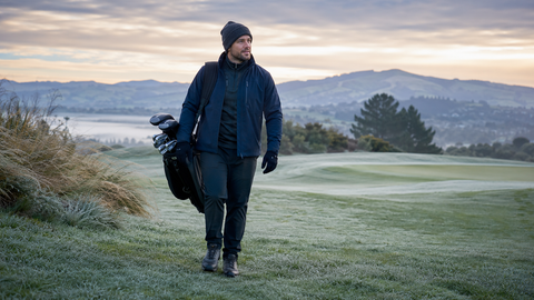 A golfer rugged up in warm clothes on a frosty golf course