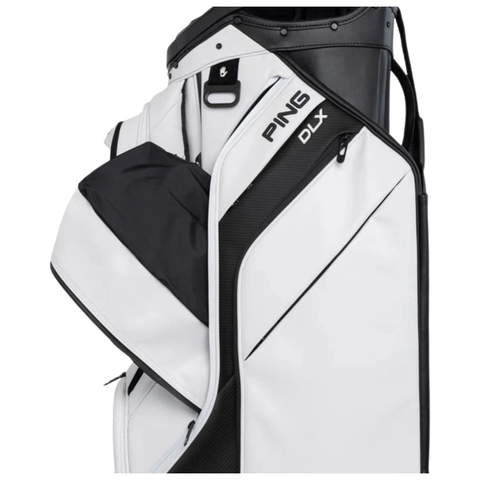 A close-up of the PING 2026 DLX 244 Cart Golf Bag in white by Ping, featuring a 15-way top, multiple zippered pockets, and spacious compartments.