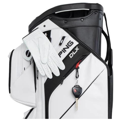 A white Ping 2026 DLX 244 Cart Golf Bag with a golf glove draped on the side and a car key attached to the front pocket, highlighting its tour-level cart design.