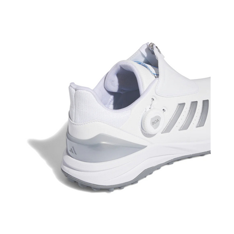 Close-up of the Adidas 2024 Men’s Solarmotion BOA Spikeless Golf Shoes in White/Silver, showing gray accents, three gray stripes, BOOST midsole for comfort, and the BOA Fit System closure. Photographed on a white background.