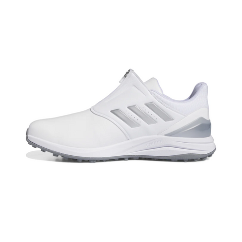 The Adidas 2024 Men’s Solarmotion BOA Spikeless Golf Shoes in White/Silver feature a slip-on design, gray sole, silver accents on the heel and side, three diagonal stripes, low-cut ankle, and a BOOST midsole for comfort.