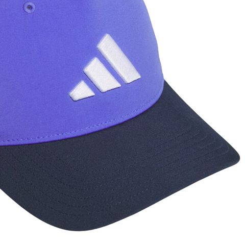 A close-up of the Adidas Colourblock Snapback Hat shows its purple crown, black curved brim, white three-bar logo, and adjustable snapback closure for a custom fit.