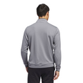 A man faces away from the camera in an Adidas Mens Core Lightweight Zip Top in light gray and dark pants, set against a plain white background.