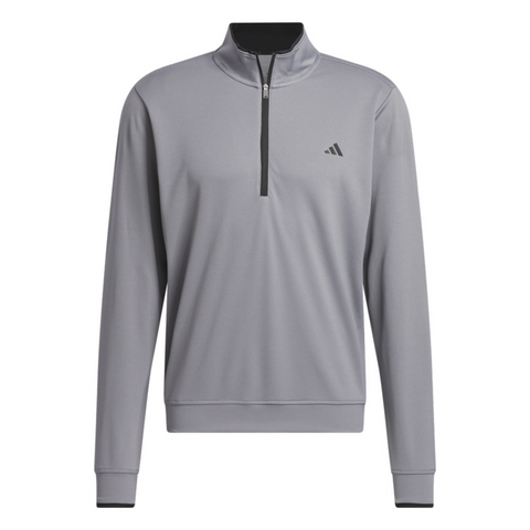 The Adidas Mens Core Lightweight Zip Top is a light gray, long-sleeve golf layer with a black quarter-zip, black inner collar, and an Adidas logo on the left chest—ideal for staying cool and comfortable on the course.