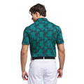 A man faces away in an Adidas Mens Go-To Printed Polo Shirt (Pure Teal/Ivy), featuring lightweight performance fabric, paired with white pants and a black belt, standing against a white background.