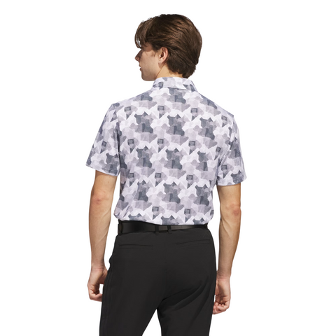 A man stands facing away in the Adidas Mens Go-To Printed Polo Shirt in White/Collegiate Navy and black pants, set against a white background.